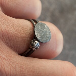 May include: A silver ring with a textured ball and a round, flat, silver disc.