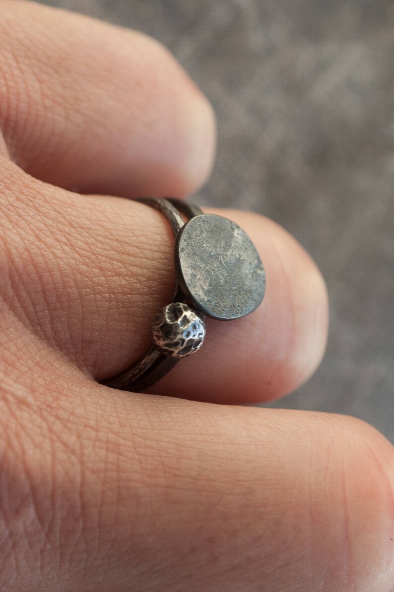 May include: A silver ring with a textured ball and a round, flat, silver disc.