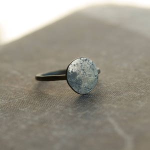 May include: A silver ring with a round, textured, silver top.