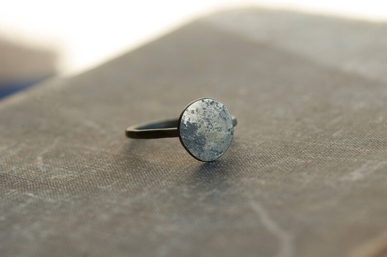May include: A silver ring with a round, textured, silver top.