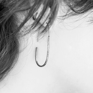 Pu&ograve; includere: Un orecchino a cerchio in argento con finitura testurizzata.