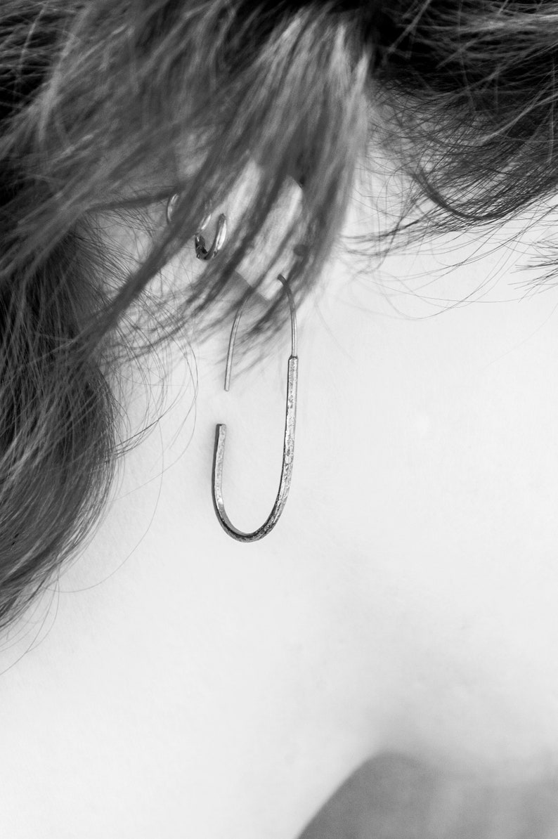 Pu&ograve; includere: Un orecchino a cerchio in argento con finitura testurizzata.