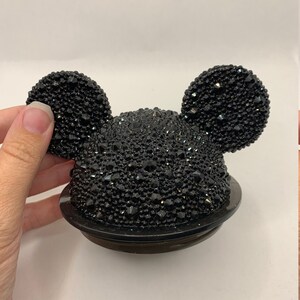 May include: Black Mickey Mouse-shaped bottle stopper covered in black rhinestones.