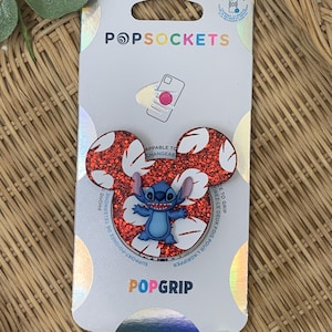 May include: A white ceramic mug with a black handle and the text "But First, Coffee" in a bold, black font. The mug is set against a blurred background, highlighting its clean design.