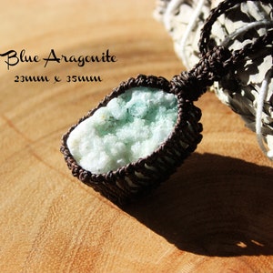K&ouml;nnte beinhalten: Ein hellblauer Aragonit-Kristall-Anh&auml;nger, der 23 mm x 35 mm misst, ist in braunes Band gewickelt und h&auml;ngt an einem wei&szlig;en Salbei-Reinigungsstab.  Blauer Aragonit 23 mm x 35 mm.