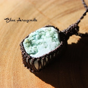 K&ouml;nnte beinhalten: Ein blauer Aragonit-Anh&auml;nger, umwickelt mit braunem Kordel, mit dem Text "Blue Aragonite" dar&uuml;ber.
