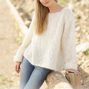 May include: A white knitted sweater with a loose fit and a round neckline. The sweater is made with a textured yarn and has a relaxed, casual style.