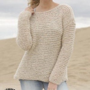 May include: A cream-colored knitted sweater with a loose fit and long sleeves. The sweater has a subtle speckled pattern.