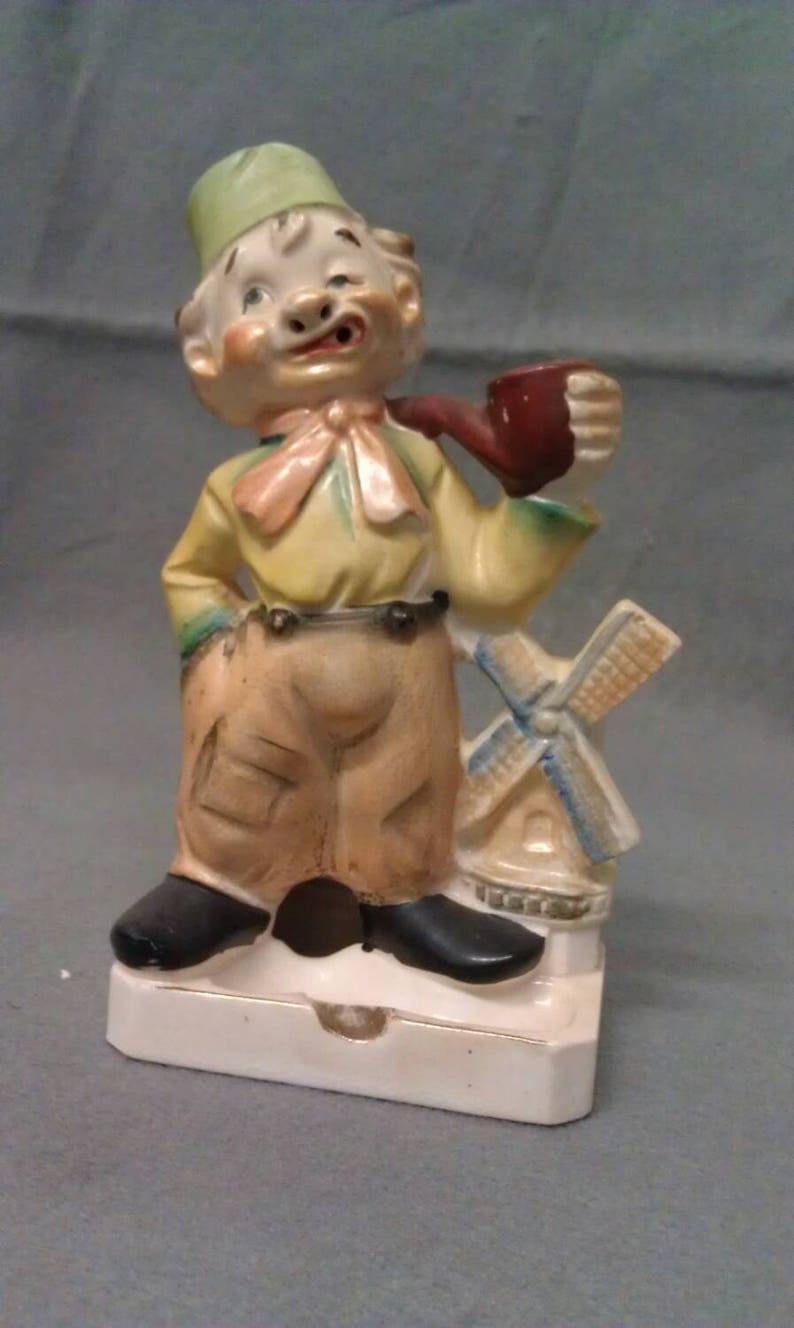Vintage Man Hobo Look with Cigar standing by Lighthouse Man on Ashtray