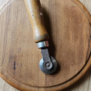 May include: A vintage wooden-handled leather sewing wheel with a metal wheel and the text "AMERICAN AUTOMOTIVE PRODUCTS, INC.  U.S.A." on the side.