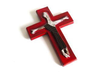 May include: A red wooden cross with a white and black figure of a person on it.