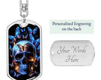 May include: A silver-colored dog tag keychain with a skull design. The skull is blue with butterfly and candle details. The tag has the text "Personalized Engraving on the back" and a blank tag with the text "Your Words Here".