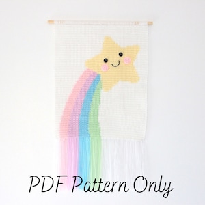 May include: A PDF pattern for a wall hanging featuring a yellow star with a smiling face and a rainbow tail. The star is against a white background.