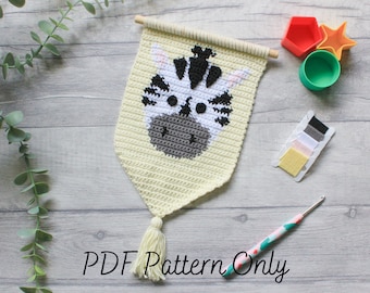 May include: A crochet wall hanging featuring a zebra face with black and white stripes. The hanging is made with a light yellow yarn and has a white tassel. The image also shows a crochet hook, yarn, and other craft supplies.