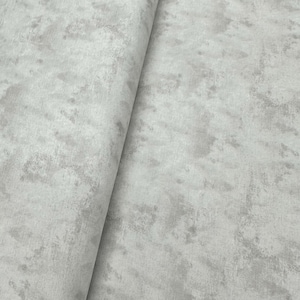May include: A close-up of a light gray fabric with a subtle, textured pattern that resembles concrete.