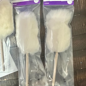 May include: Several mini dusters in clear plastic packaging. Each duster has a fluffy, off-white head attached to a wooden handle. The packaging includes the text "Mini Duster" and "GYPSY quilter".