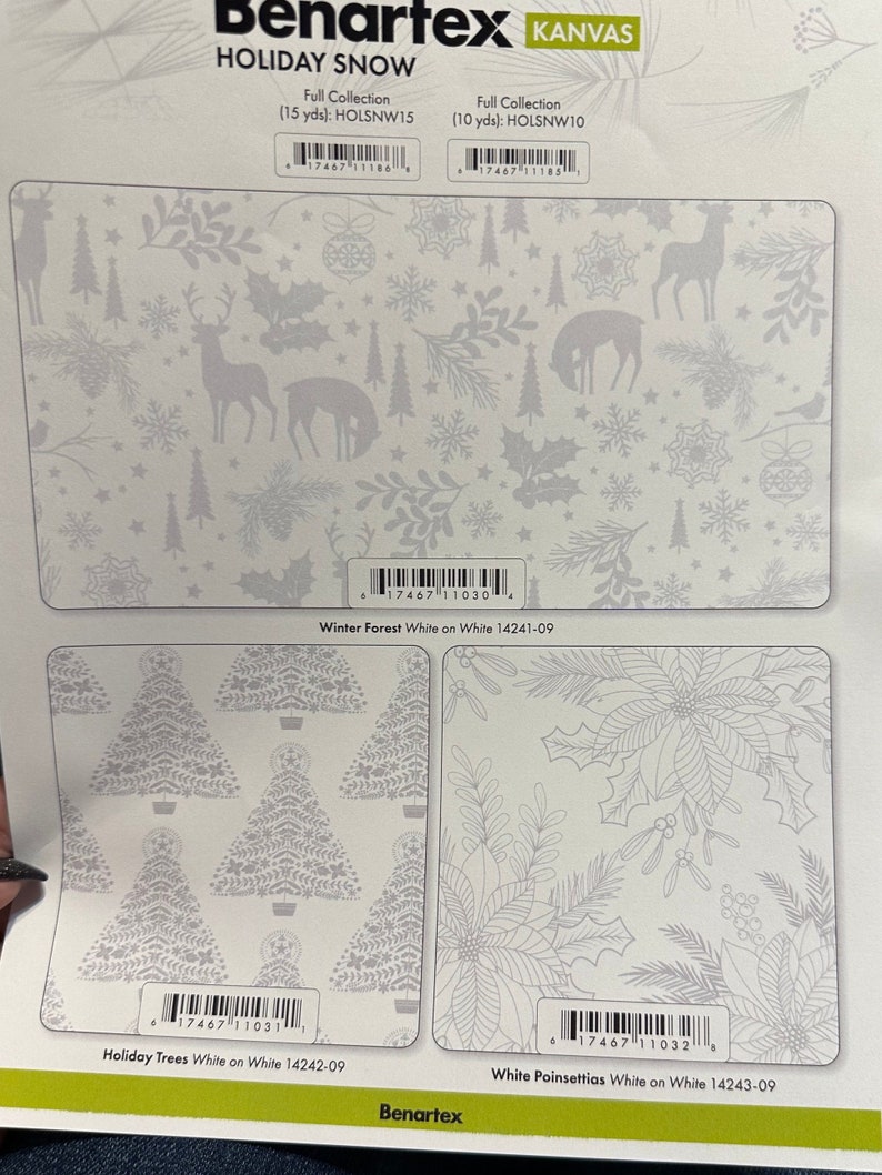 K&ouml;nnte beinhalten: Ein wei&szlig;er Stoff mit einem silbernen Schneeflocken- und Winterwald-Design. Der Stoff ist mit "Holiday Snow" beschriftet und Teil der Benartex Kanvas-Kollektion. Der Stoff ist in zwei Gr&ouml;&szlig;en erh&auml;ltlich: 15 Yards und 10 Yards.