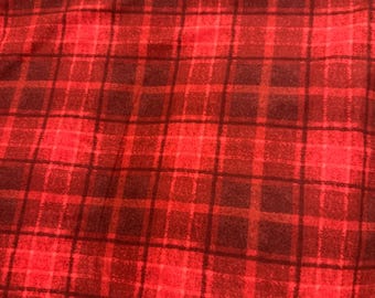 Könnte beinhalten: Ein Stoff mit einem rot und dunkelrot karierten Muster. Das Design besteht aus sich kreuzenden horizontalen und vertikalen Linien in verschiedenen Rottönen, die ein gitterartiges Erscheinungsbild auf der Oberfläche des Textilmaterials erzeugen.