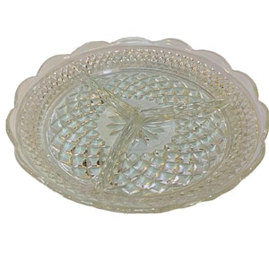 May include: A clear glass divided serving dish featuring a scalloped edge and a textured diamond pattern across the surface. The circular tray is partitioned into three equal sections by raised glass dividers, with a starburst design at the center.