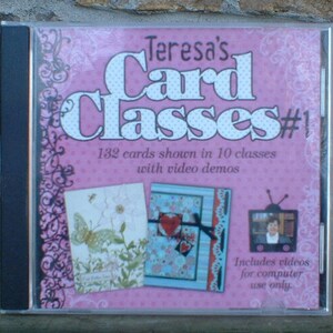May include: Pink CD case with a white polka dot background. The title is "Teresa's Card Classes #1". The case features a picture of two handmade cards and a small TV screen with a video demo. The text on the case says "132 cards shown in 10 classes with video demos" and "Includes videos for computer use only."