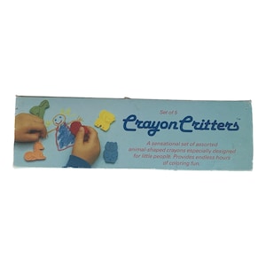 May include: A light blue box of "Crayon Critters" crayons. The box features a drawing of a person and animal-shaped crayons. The text on the box says "A sensational set of assorted animal-shaped crayons especially designed for little people."