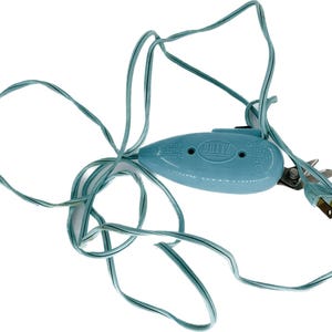 May include: A light blue Dritz electric scissors with a matching cord and a standard US plug. The scissors have a silver blade and the text "Dritz" is printed on the body. The cord is wrapped around the scissors.