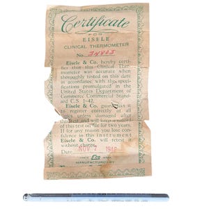 Könnte beinhalten: Vintage Eisele & Co. Klinisches Thermometer mit Zertifikat. Das Zertifikat trägt den Text "Certificate for EISELE CLINICAL THERMOMETER" und das Datum "NOV 7 1946". Das Thermometer ist aus Glas und Silber.