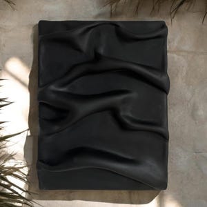 Può includere: Uno sfondo in tessuto nero con una texture grinzosa e drappeggiata. Il tessuto è liscio e sembra essere fatto di un materiale morbido.