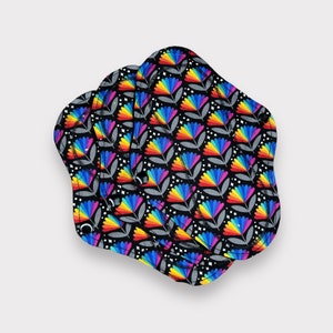 May include: Three reusable cloth menstrual pads with a black background and a rainbow floral pattern.