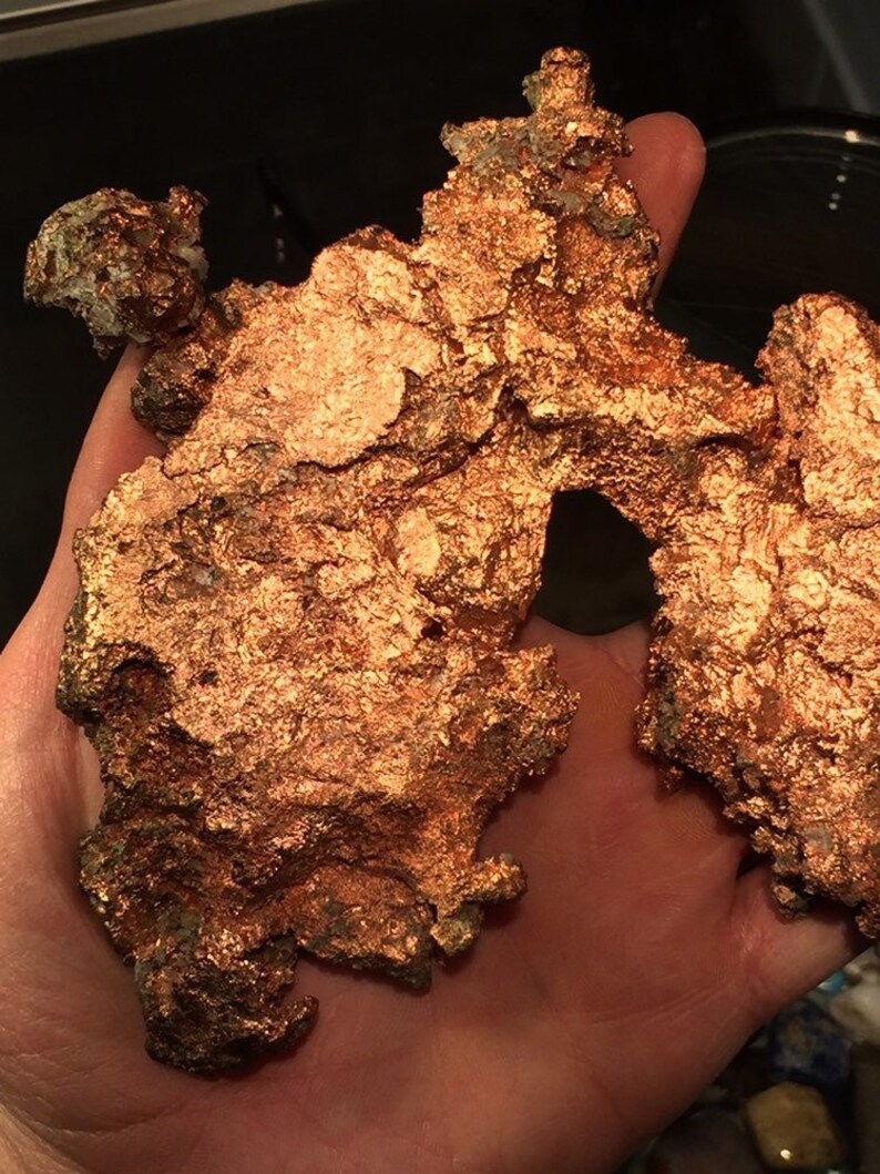 Puede incluir: Un gran trozo de mineral de cobre de forma irregular con una superficie rugosa y texturizada. El cobre tiene un color marr&oacute;n rojizo y est&aacute; cubierto por una capa de oxidaci&oacute;n.