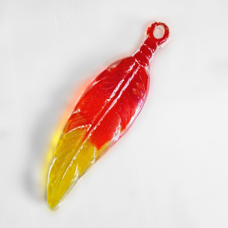 A feather made of glass in red, orange and yellow