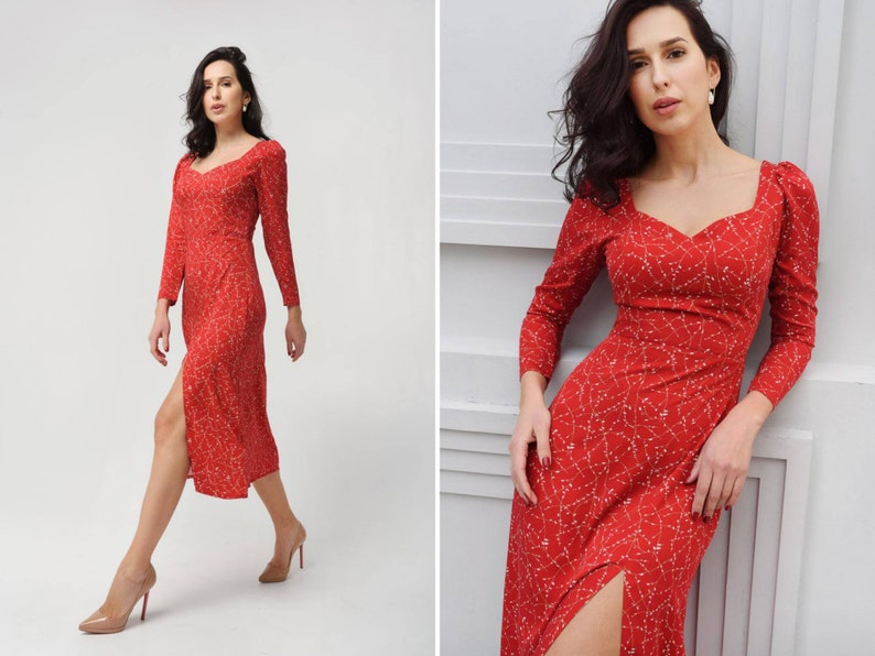 May include: A red midi dress with a white floral pattern and a side slit. The dress has a sweetheart neckline and long sleeves.