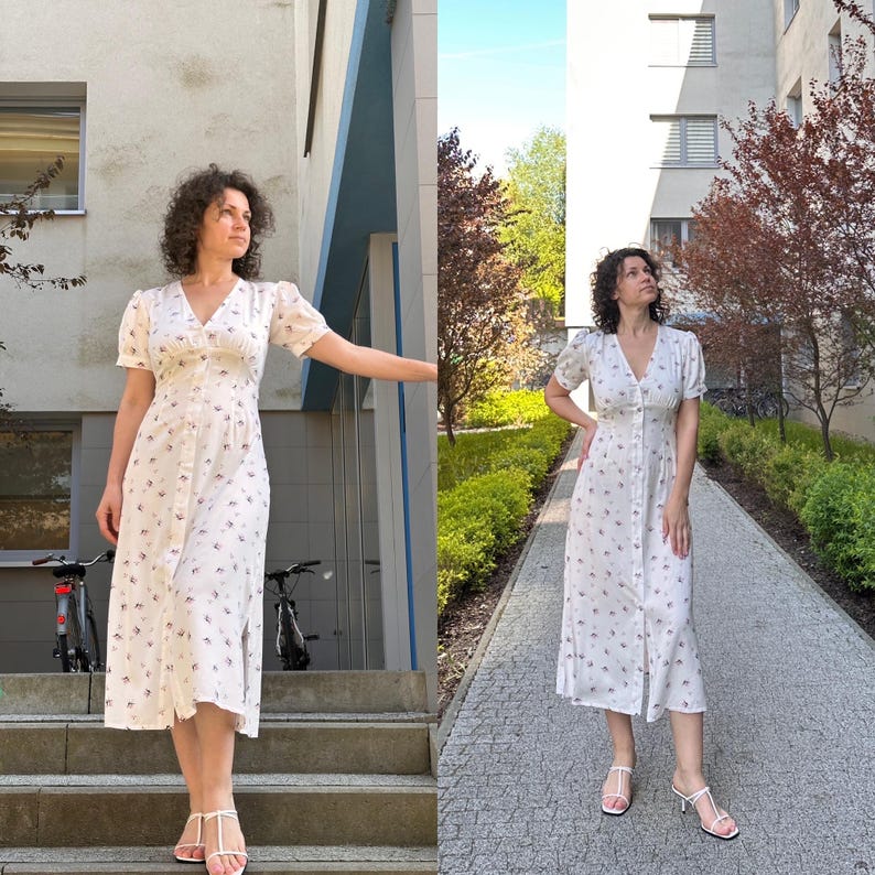 K&ouml;nnte beinhalten: Wei&szlig;es Midikleid mit floralem Muster, Knopfleiste, kurzen Puff&auml;rmeln und V-Ausschnitt. Das Kleid hat einen Seitenschlitz. Das Model tr&auml;gt wei&szlig;e Sandalen. Das Kleid ist knielang.