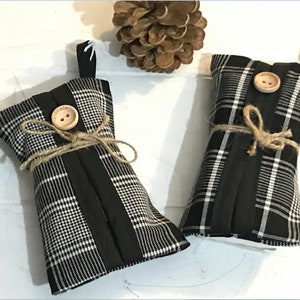 May include: Two black and white plaid fabric tissue holders with brown buttons and twine tied around them.