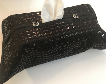 May include: Black tissue box cover with a geometric pattern of sequins. The cover has two decorative buttons with rhinestones.