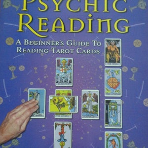 May include: A book titled How to Perform a Psychic Reading: A Beginner's Guide to Reading Tarot Cards by James Gregory. The purple cover features yellow text and a layout of various tarot cards including The Hermit, The Fool, and The Devil.