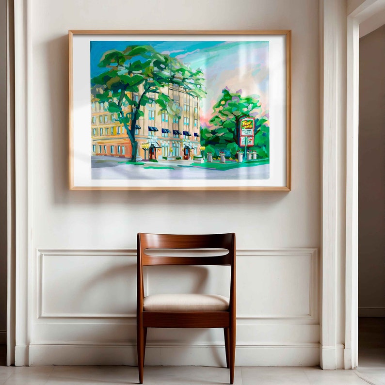 May include: A painting of a building with a green tree in front of it. The building is painted in a light blue and white color scheme. The tree is painted in shades of green and yellow. The painting is framed in a light wood frame.