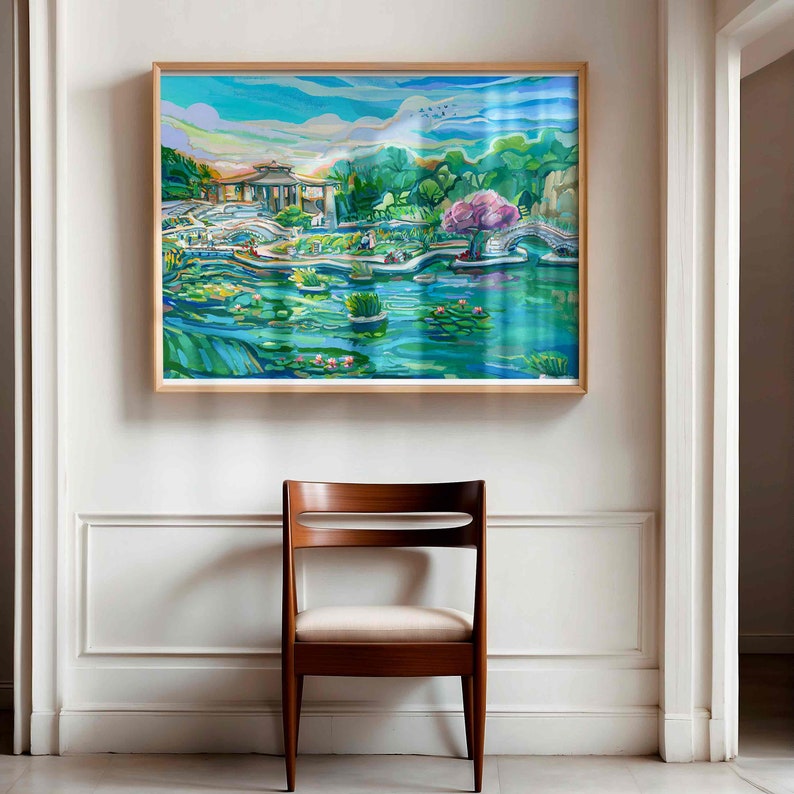 May include: A framed painting of a colorful landscape with a pond, trees, and a bridge. The painting is in a light wood frame and is hanging on a white wall.