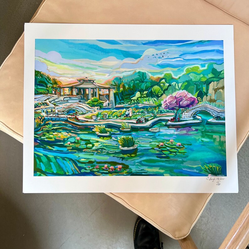 May include: A colorful painting of a Japanese garden with a pagoda, a bridge, a pond with lily pads, and a pink flowering tree. The painting is done in a vibrant style with bold strokes and bright colors.