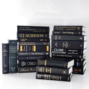 May include: A collection of hardcover books in various sizes and titles. The books are primarily black with gold or white lettering. Titles include "Marlborough," "Acheson," and "Close Encounters." The books are stacked and arranged on a white surface.