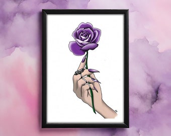 Puede incluir: Una mano con uñas largas pintadas sostiene una sola rosa púrpura. La mano lleva varios anillos con piedras negras.
