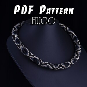 Könnte beinhalten: Eine schwarze und silberne Perlenkette mit geometrischem Muster. Die Kette befindet sich auf einer schwarzen Mannequin-Büste. Der Text "PDF PATTERN HUGO" befindet sich oben im Bild.