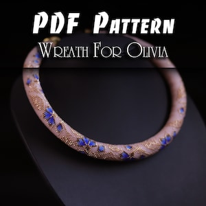 Pode incluir: Padrão PDF para uma grinalda de contas com um delicado design floral em tons de rosa, azul e dourado. O texto "Wreath for Olivia" é visível na parte superior da imagem.