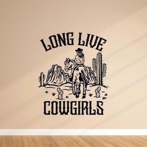 May include: Black and white silhouette of a cowgirl riding a horse with the text "Long Live Cowgirls" above and cacti in the background.