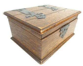 May include: A wooden box with a hinged lid and metal accents. The box is made of dark wood and has a rustic appearance.
