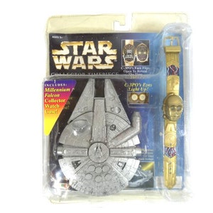 Op de afbeelding: Een Star Wars verzamelaarshorloge set met een Millennium Falcon horlogekoffer en een C-3PO horloge met lichtgevende ogen. De wijzerplaat van het horloge klapt open om een C-3PO afbeelding te onthullen.