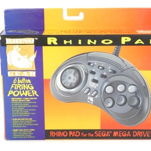 May include: A black Rhino Gear Rhino Pad gamepad for the Sega Mega Drive. The box features a rhino logo and the text "6 button firing power".