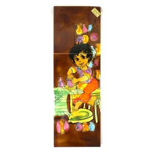 May include: A colorful ceramic tile depicting a child working on a pottery wheel, surrounded by various pottery pieces. The tile has a brown background and features a whimsical style.