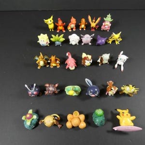 Può includere: Una collezione di 25 figurine di Pokemon in plastica colorate. Le figurine sono tutte personaggi diversi del franchise di Pokemon, tra cui Pikachu, Charmander, Bulbasaur, Squirtle e molti altri.