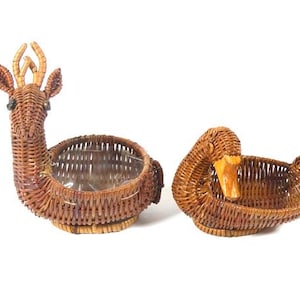 May include: Two woven wicker baskets shaped like a deer and a duck. The deer basket has a clear plastic liner. Both baskets are brown.